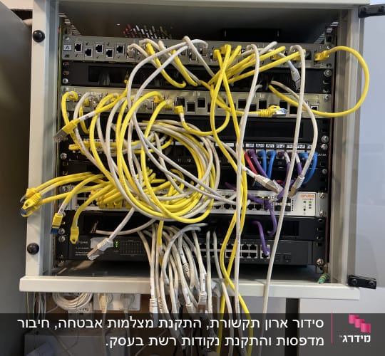ארון תקשורת עם כבלים צהובים ולבנים מחוברים